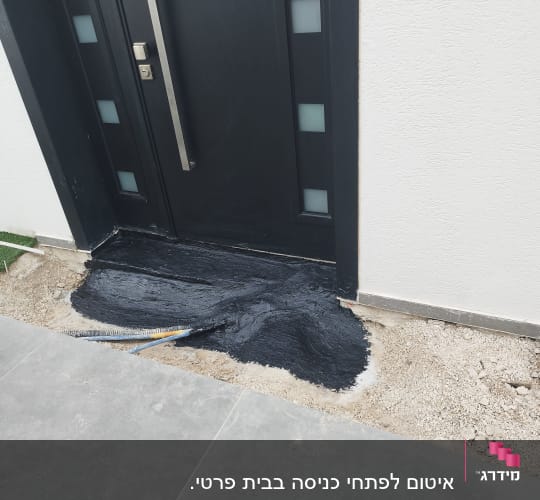 איטום שחור ליד דלת כניסה על רצפה
